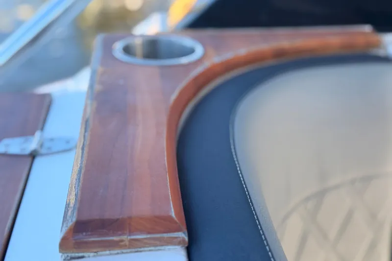 Slide: The Image of Close-up of NX Boats 360 Sport Coupe 2023, featuring wooden trim and cup holder detail. - 76