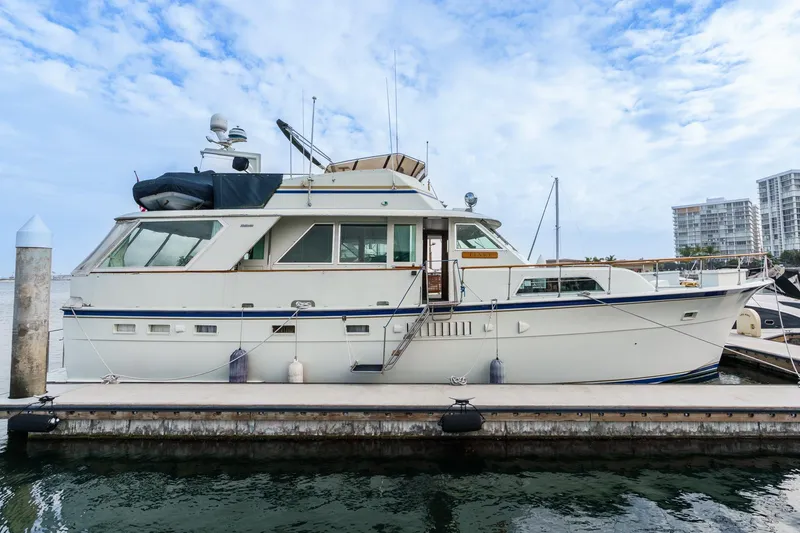 Slide: The Image of 1971 Hatteras 53 Motor Yacht docked at marina, under a partly cloudy sky. - 1