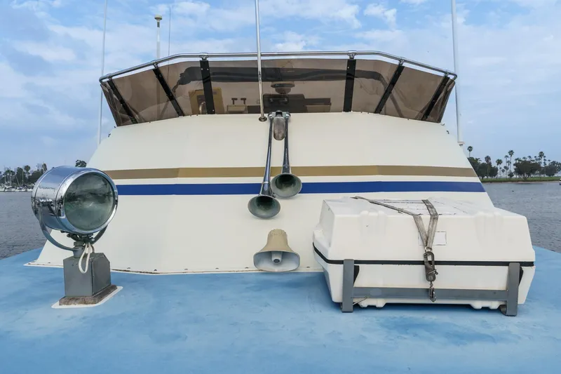Slide: The Image of 1971 Hatteras 53 Motor Yacht deck with spotlight and life raft, under a clear sky. - 11