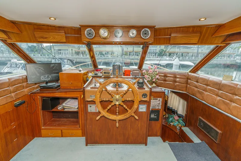 Slide: The Image of 1971 Hatteras 53 Motor Yacht helm with wooden wheel, gauges, and leather seating. - 24
