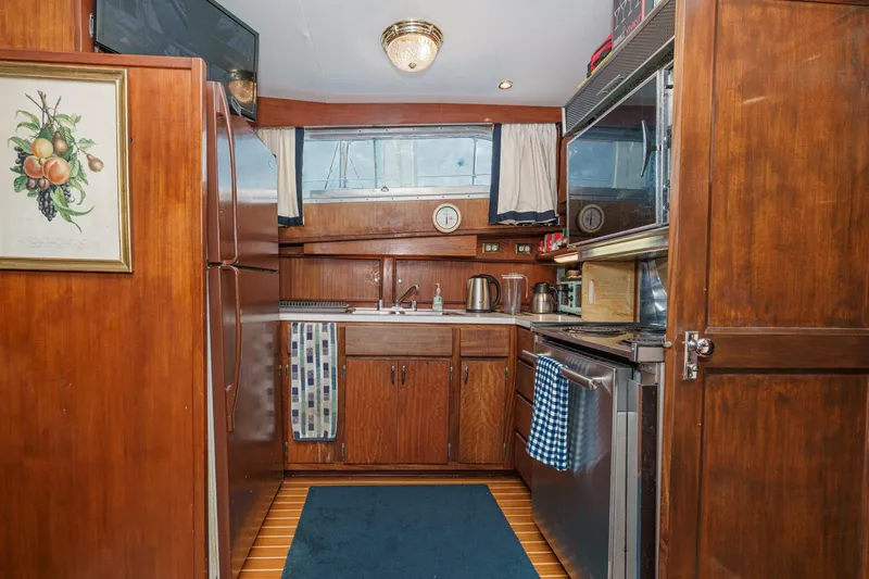 Slide: The Image of 1971 Hatteras 53 Motor Yacht kitchen with wood cabinetry and nautical decor. - 36