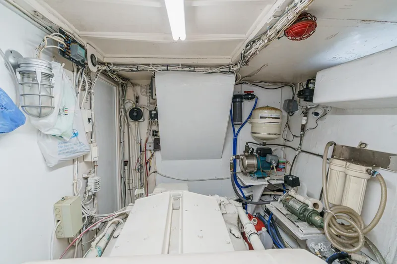 Slide: The Image of Engine room of a 1971 Hatteras 53 Motor Yacht, showcasing mechanical equipment and wiring. - 59