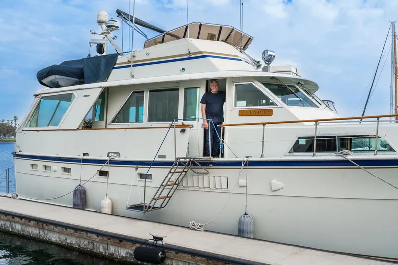 Slide: The Image of 1971 Hatteras 53 Motor Yacht docked with person on deck, clear sky background. - 73