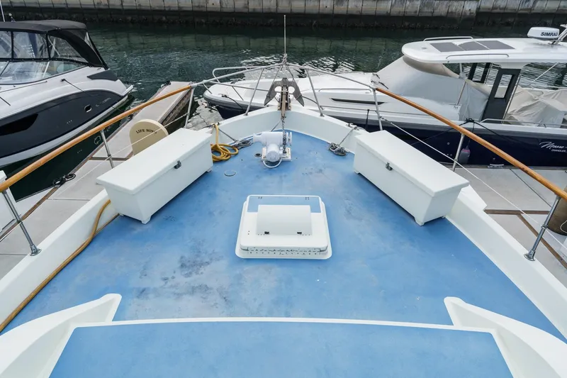 Slide: The Image of 1971 Hatteras 53 Motor Yacht deck with storage benches and marina view. - 8