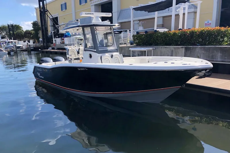 Slide: The Image of 2016 Tidewater 280 CC Adventure boat docked at marina, featuring sleek design and Garmin equipment. - 2
