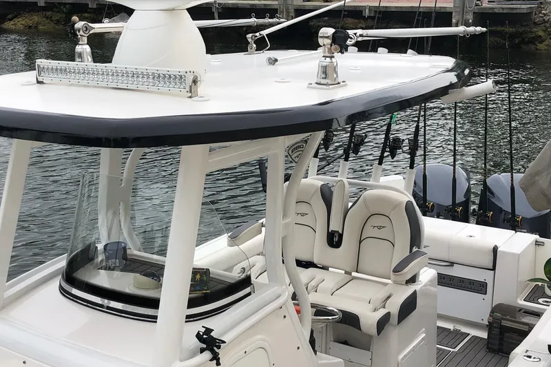 Slide: The Image of 2016 Tidewater 280 CC Adventure boat with fishing gear and seating, docked by the water. - 6