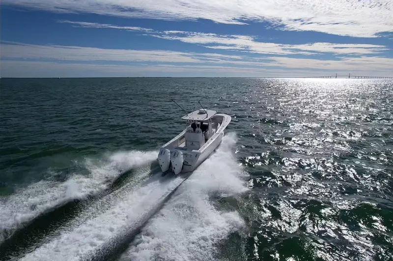 Slide: The Image of 2024 Front Runner 33 Center Console boat cruising on open water under a sunny sky. - 13