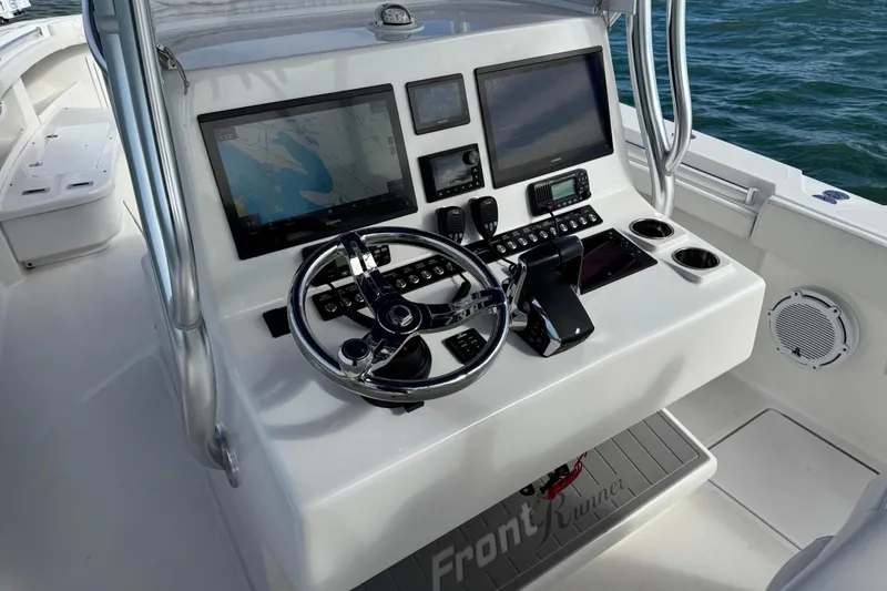 Slide: The Image of 2024 Front Runner 33 Center Console boat dashboard with navigation screens and controls. - 21