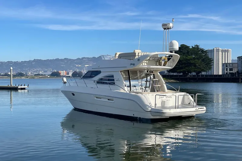 Slide: The Image of 2003 Cranchi Atlantique 40 yacht on calm water, cityscape in background. - 2