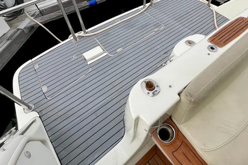 Slide: The Image of 2003 Cranchi Atlantique 40 yacht deck with sleek gray flooring and white seating. - 24