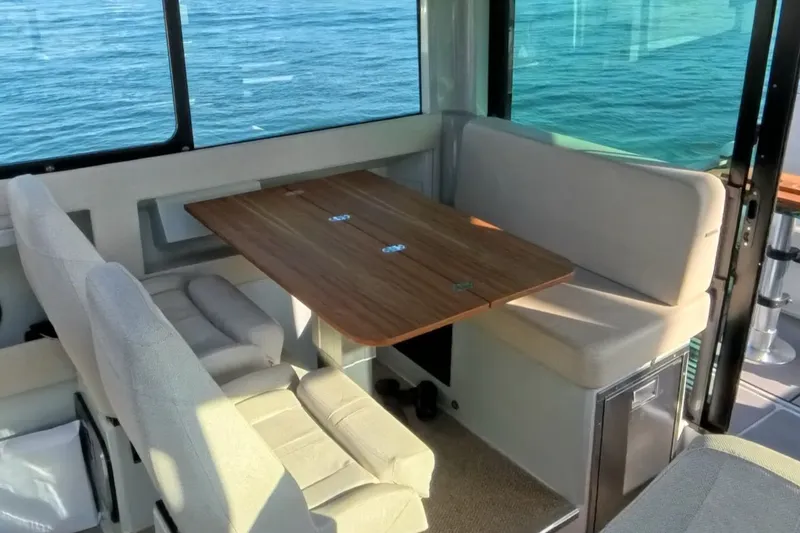 Slide: The Image of 2024 Saxdor 320 GTC interior with cozy seating and wooden table, overlooking the ocean. - 53