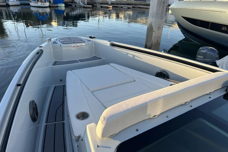 Slide: The Image of 2024 Saxdor 320 GTC boat with cushioned seating, docked in a marina. - 61