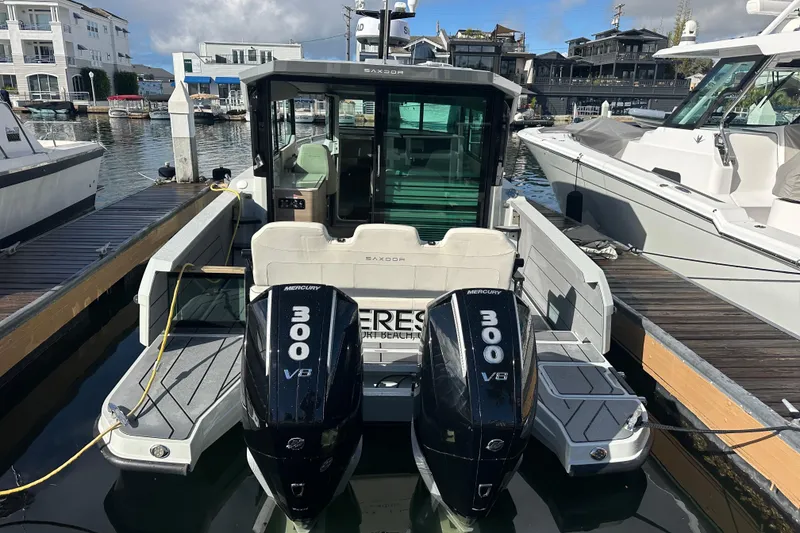 Slide: The Image of 2024 Saxdor 320 GTC boat with dual Mercury 300 V8 engines docked in marina. - 72