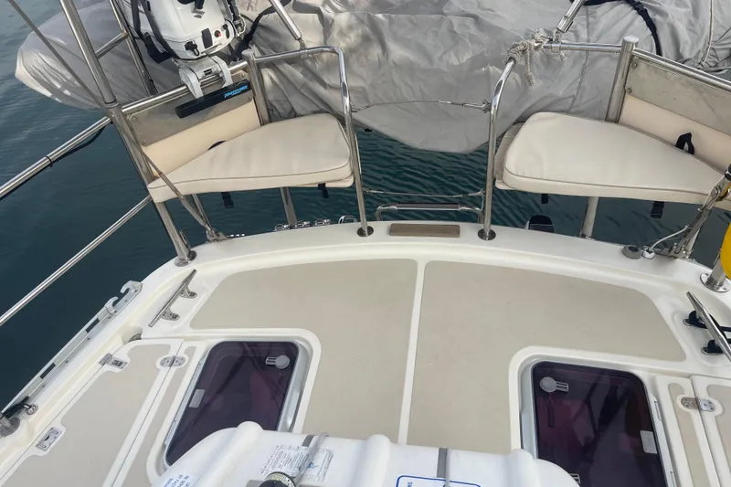 Slide: The Image of 2008 Caliber center cockpit cutter sailboat docked, featuring deck equipment and liferaft. - 11