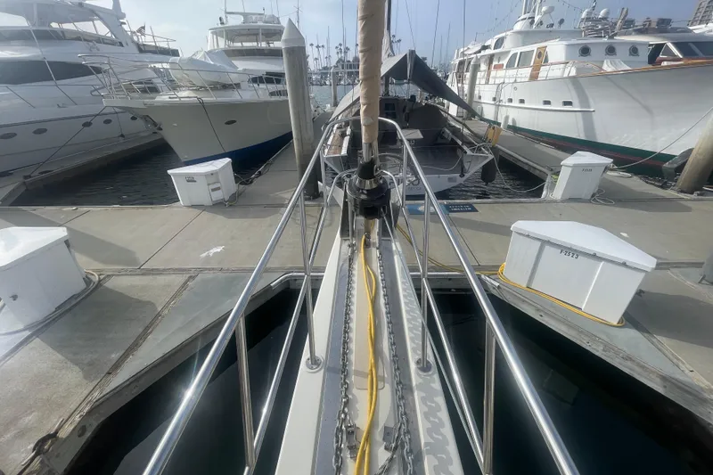 Slide: The Image of 2008 Caliber center cockpit cutter at marina, featuring covered equipment and seating area. - 24