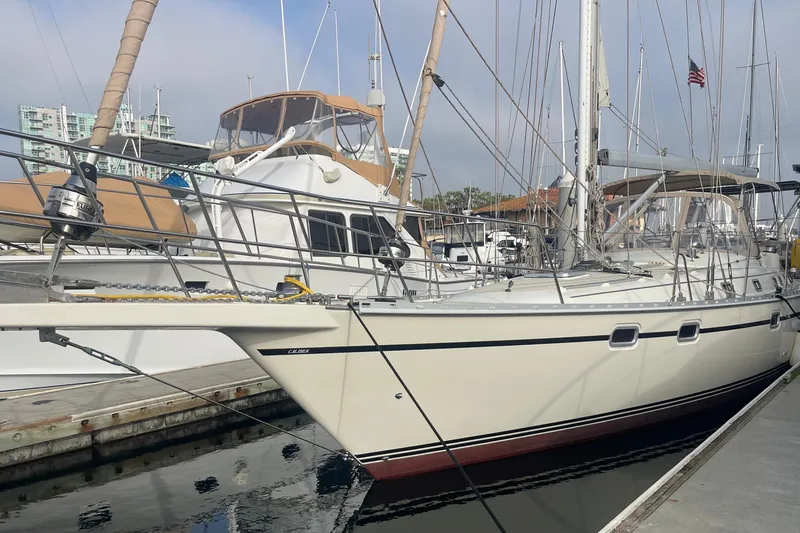 Slide: The Image of 2008 Caliber center cockpit cutter sailboat anchored on calm blue water. - 5