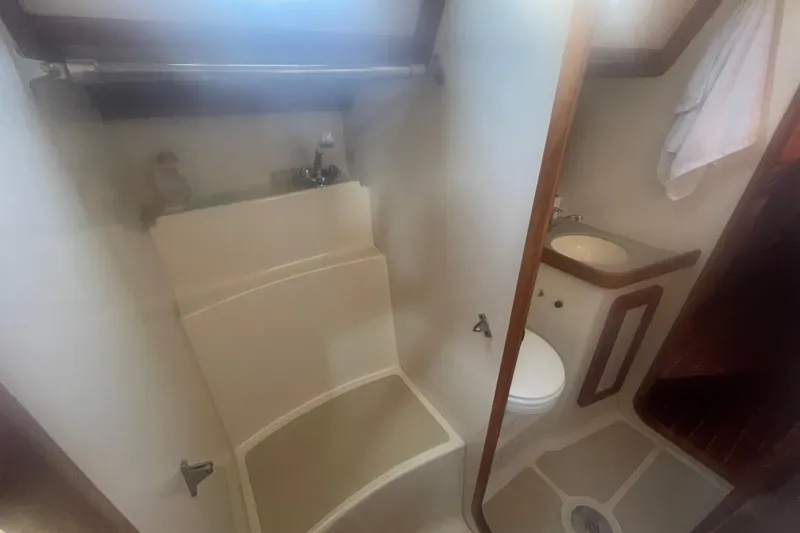 Slide: The Image of 2008 Caliber center cockpit cutter cabin with cozy bed, books, and life jackets. - 59