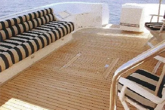 Slide: The Image of Luxurious Dyna Laguna yacht deck with striped seating, overlooking the water. - 13