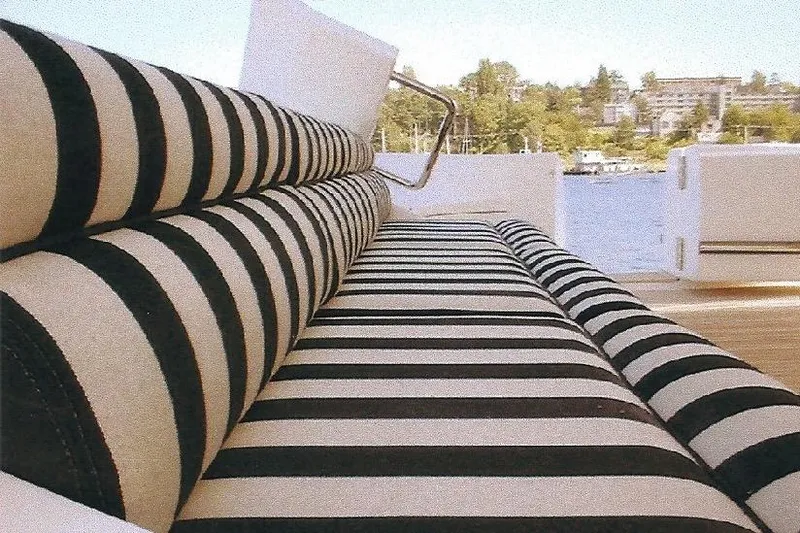 Slide: The Image of Striped seating on a Dyna Laguna boat with a scenic waterfront view. - 14