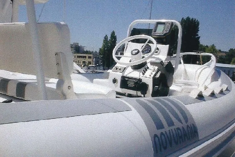Slide: The Image of RIB boat with steering console, featuring Dyna Laguna model, docked in a marina. - 19