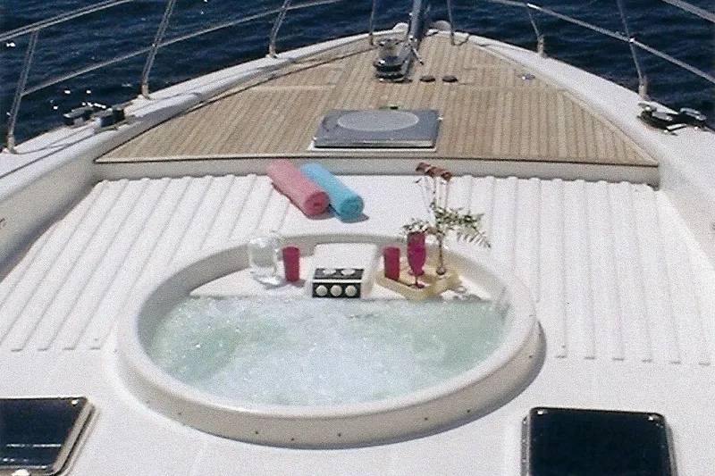 Slide: The Image of Luxurious Dyna Laguna yacht deck with jacuzzi, drinks, and towels, overlooking the ocean. - 20