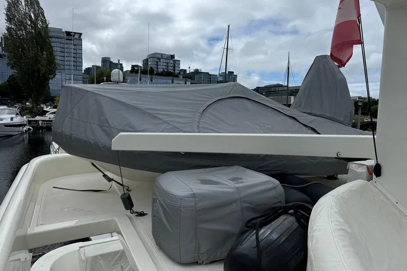 Slide: The Image of Covered Dyna Laguna boat on deck, urban marina backdrop, overcast sky. - 24