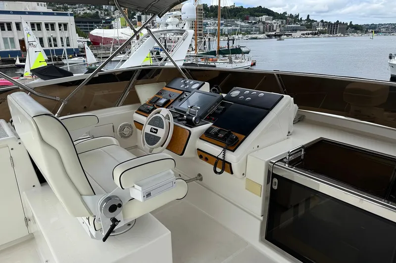 Slide: The Image of Cockpit of Dyna Laguna yacht with steering wheel and control panels, docked at marina. - 27