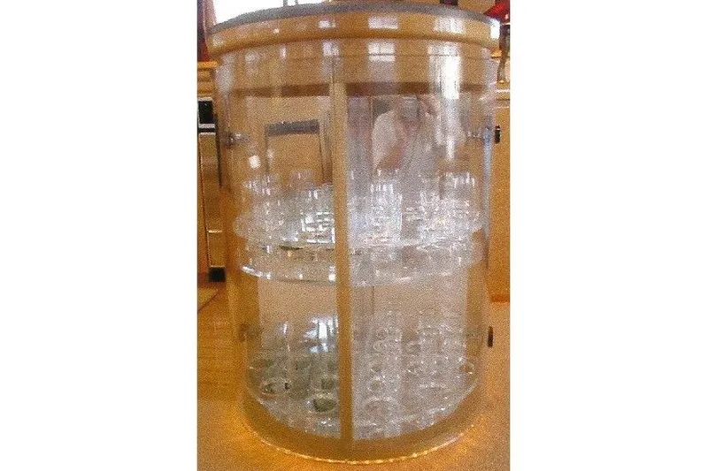 Slide: The Image of Clear cylindrical display case with glass shelves, showcasing various glassware. - 42