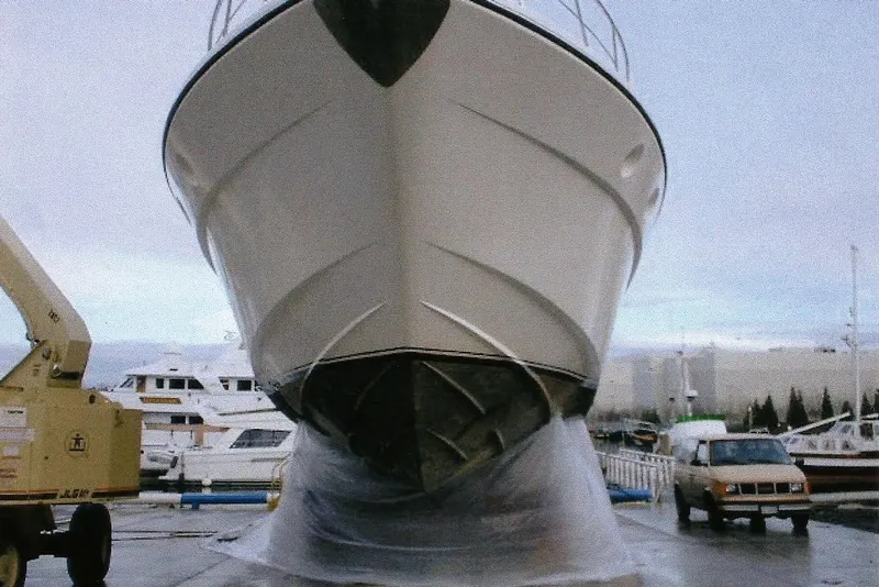Slide: The Image of Dyna Laguna yacht in a shipyard, with vehicles and other boats in the background. - 8