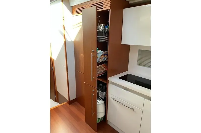 Slide: The Image of 2014 Beneteau Gran Turismo 49 yacht kitchen with wooden cabinets and modern appliances. - 17