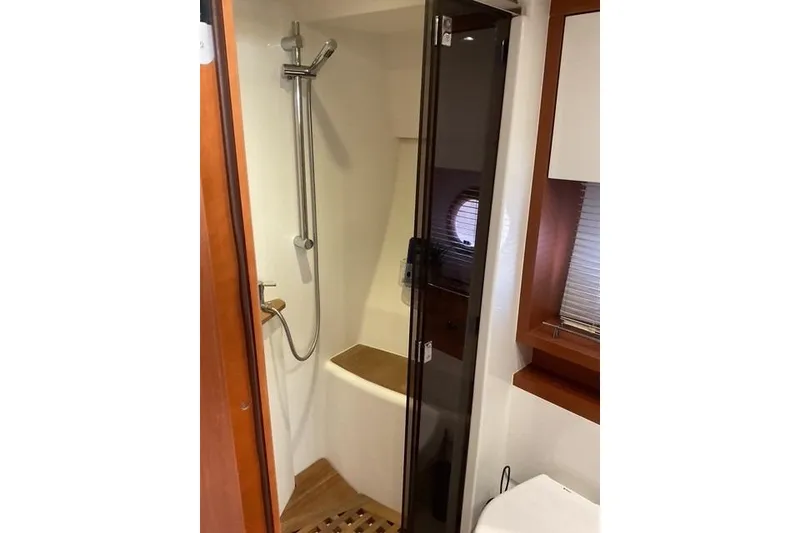 Slide: The Image of 2014 Beneteau Gran Turismo 49 yacht bathroom with shower and wooden accents. - 27