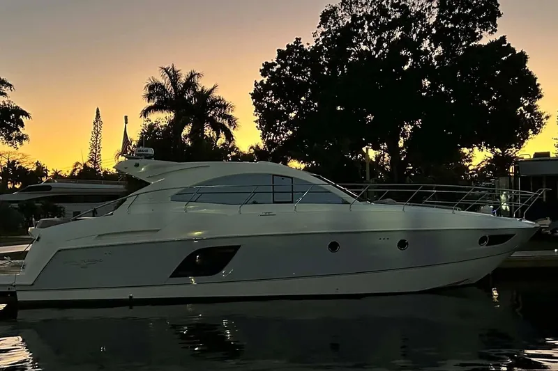 Slide: The Image of 2014 Beneteau Gran Turismo 49 yacht at sunset, silhouetted by trees and a vibrant sky. - 3