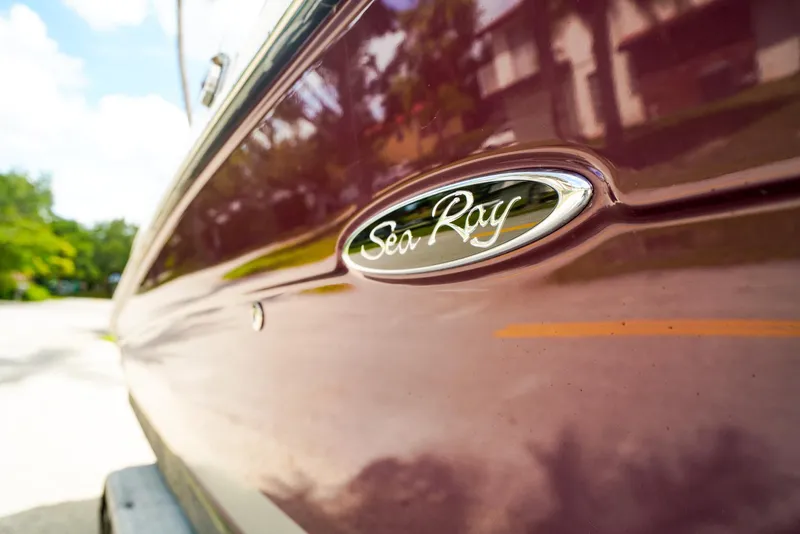 Slide: The Image of Close-up of 2010 Sea Ray 270 SLX boat logo on a glossy maroon surface. - 27