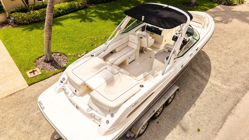 Slide: The Image of 2010 Sea Ray 270 SLX boat on trailer, parked near lush green lawn. - 5