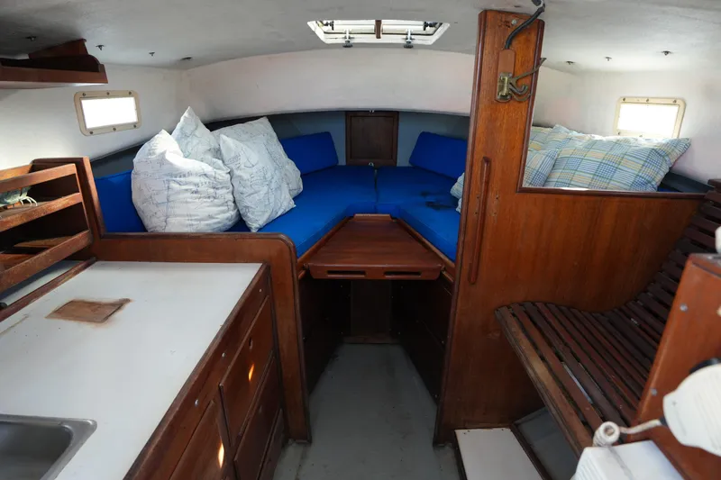 Slide: The Image of Interior of 1983 SISU 26 boat with blue cushions and wooden cabinetry. - 4