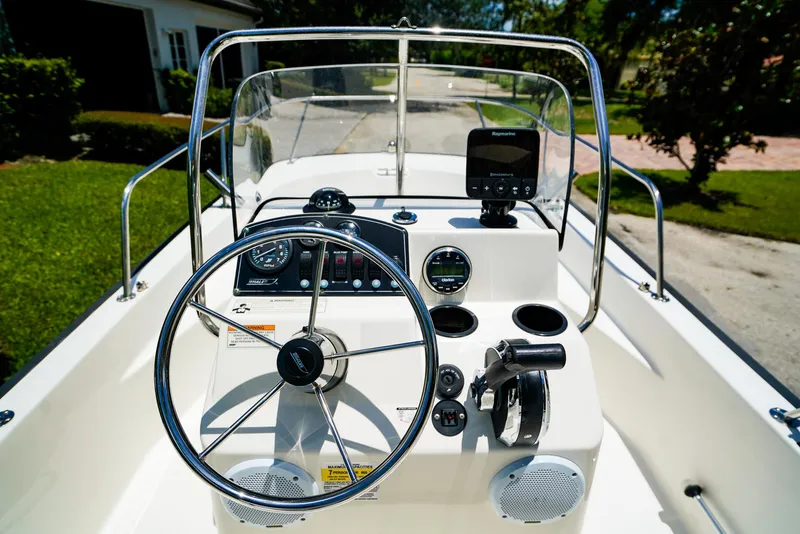 Slide: The Image of 2016 Boston Whaler 170 Montauk boat dashboard with steering wheel and controls. - 10