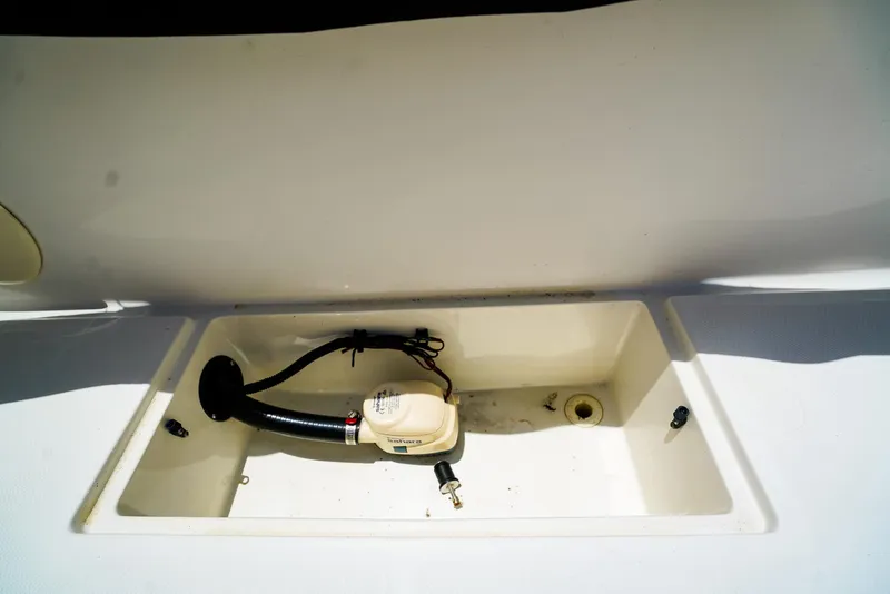Slide: The Image of 2016 Boston Whaler 170 Montauk boat compartment with pump and hose. - 18
