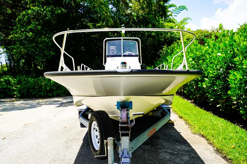 Slide: The Image of 2016 Boston Whaler 170 Montauk boat on trailer, surrounded by greenery. - 19