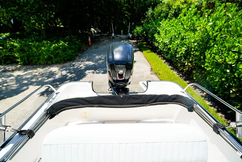 Slide: The Image of 2016 Boston Whaler 170 Montauk boat with outboard motor, parked on a sunny driveway. - 3