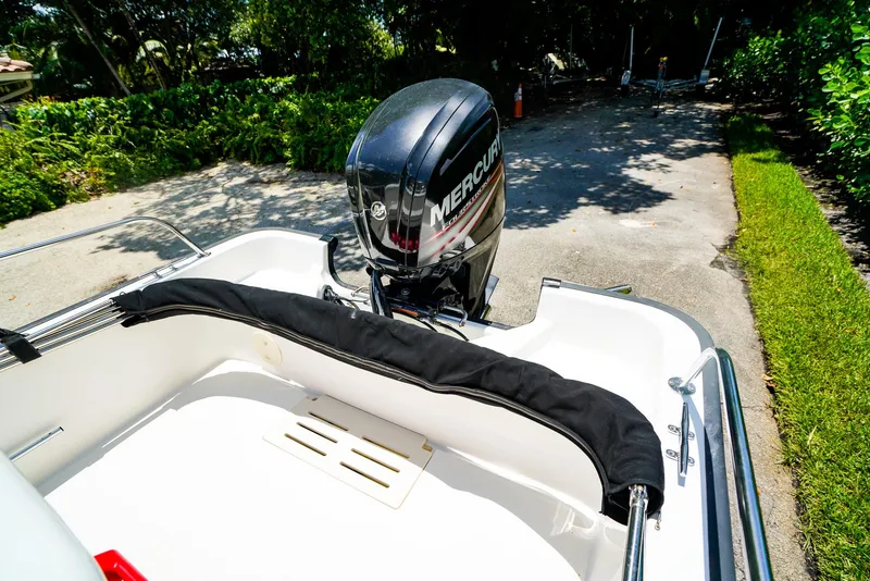 Slide: The Image of 2016 Boston Whaler 170 Montauk boat with Mercury engine, parked outdoors. - 4
