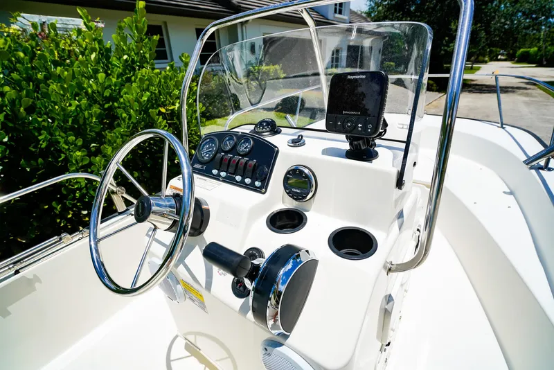 Slide: The Image of 2016 Boston Whaler 170 Montauk boat dashboard with steering wheel and navigation equipment. - 9