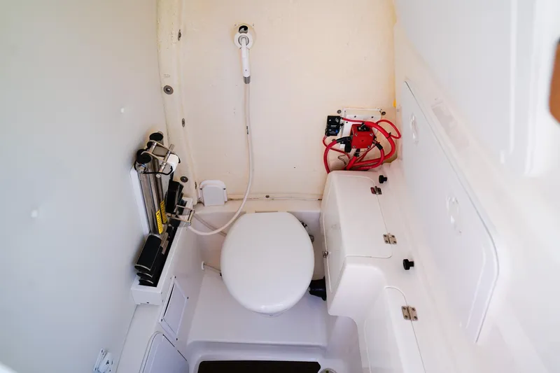 Slide: The Image of Interior of 2021 Tidewater 256 LXF boat bathroom with toilet and showerhead. - 17