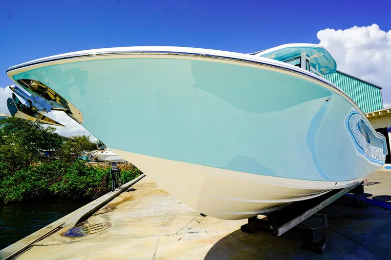 Slide: The Image of 2021 Tidewater 256 LXF boat on dock, sleek design, blue sky background. - 2