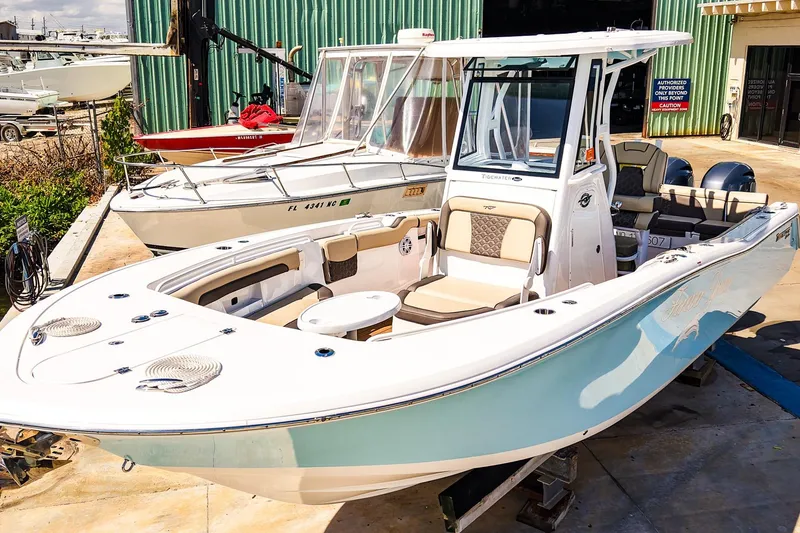 Slide: The Image of 2021 Tidewater 256 LXF boat with sleek design, docked at a marina. - 30