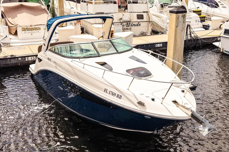 The Image of 2015 Sea Ray 260 Sundancer docked in marina, featuring sleek design and blue hull. - 1