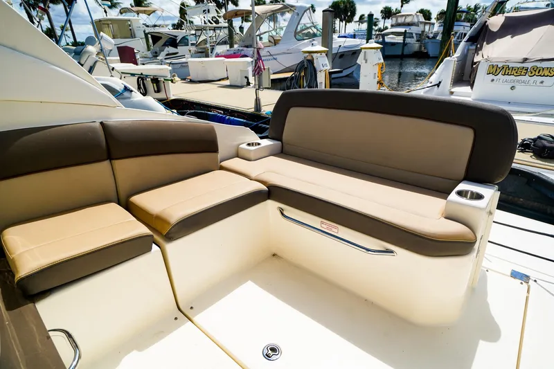 Slide: The Image of 2015 Sea Ray 260 Sundancer boat interior with beige seating at marina. - 10