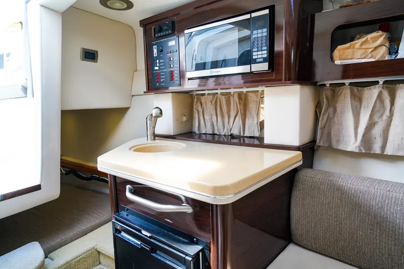 Slide: The Image of 2015 Sea Ray 260 Sundancer cabin interior with kitchenette, microwave, and sink. - 19