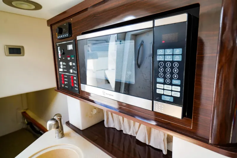 Slide: The Image of 2015 Sea Ray 260 Sundancer interior with microwave and control panel. - 20