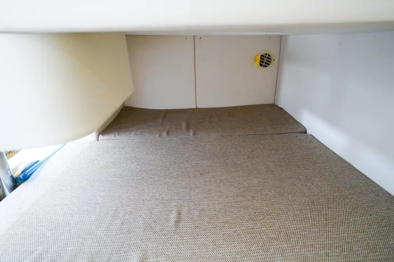 Slide: The Image of 2015 Sea Ray 260 Sundancer cabin interior with cushioned sleeping area. - 23