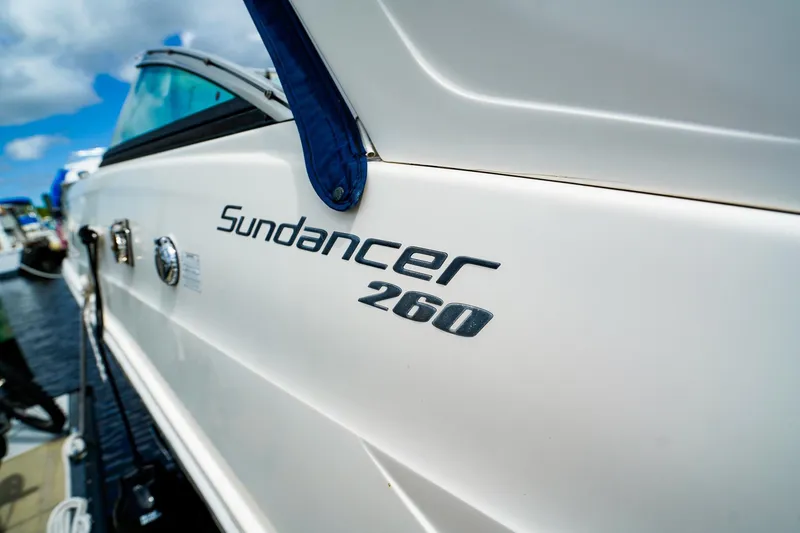 Slide: The Image of 2015 Sea Ray 260 Sundancer boat docked, showcasing sleek design and branding. - 31